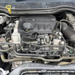 A Ford engine bay after work, cover back on, dipstick in